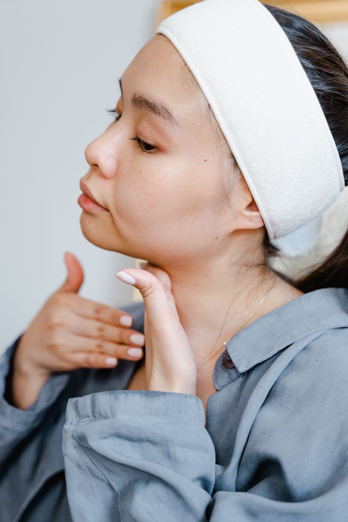 Mujer aplicando crema de cuidado enfocada en el cuello