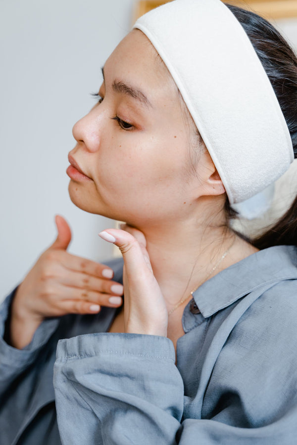 Mujer aplicando crema de cuidado enfocada en el cuello