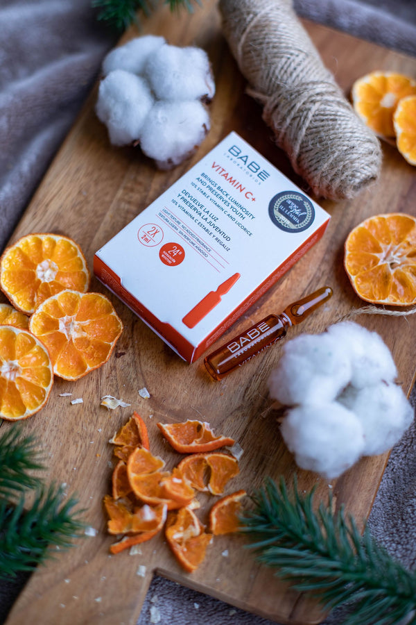 Sérum de vitamina C con rodajas de naranja sobre madera