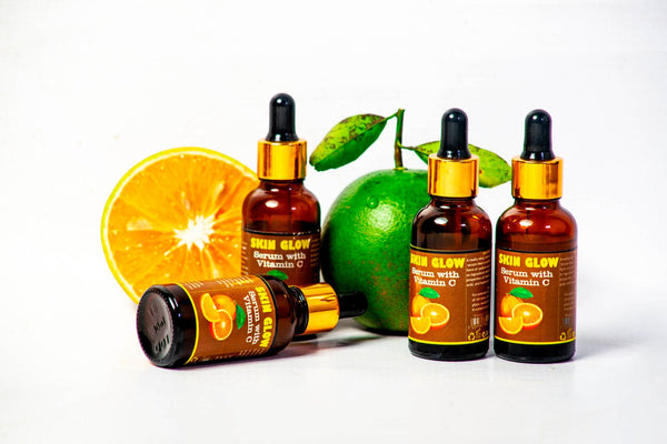 Frascos de sérum de vitamina C con cítricos frescos