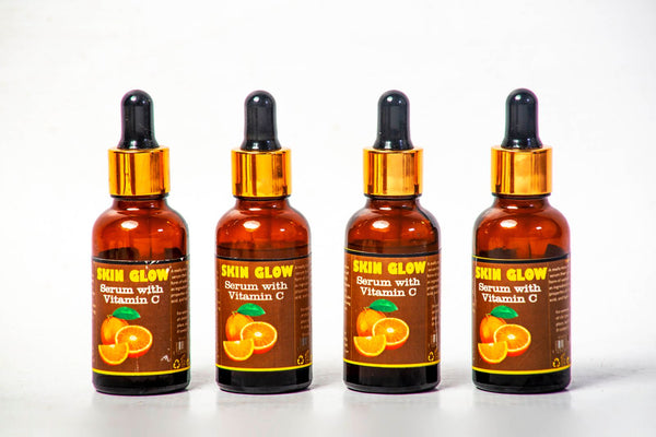 Cuatro frascos de sérum de vitamina C organizados sobre fondo blanco